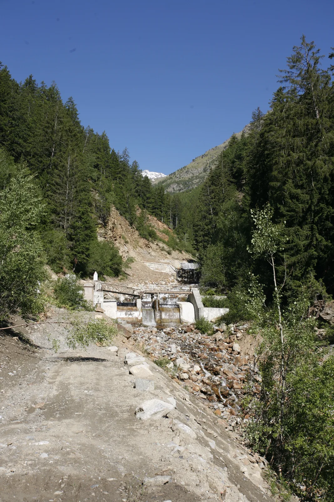 Paesaggio montano con opere lungo un corso d’acqua documentate da Mazzoni Costruzioni